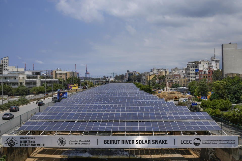Cars pass by solar panels installed over the Beirut River, in Beirut, Lebanon, Thursday, May 30, 2024. Lebanese caretaker Minister of Economy and Trade Amin Salam said Lebanon's political class as well as fuel companies and private electricity providers in Lebanon blocked an offer by gas-rich Qatar to build three renewable energy power plants to ease the crisis-hit nation's decades-old electricity crisis. (AP Photo/Bilal Hussein)