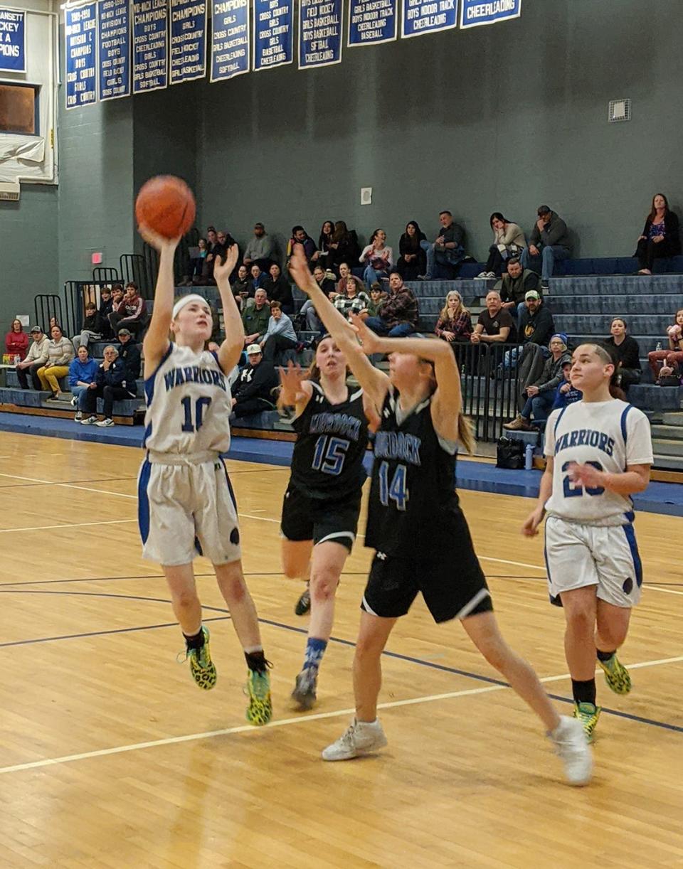 Narragansett's Faith Stillman (10) puts up a shot in the lane as Murdock's Shannon Connolly (15) and Sadie Bauver (14) defend during a game in Baldwinville.