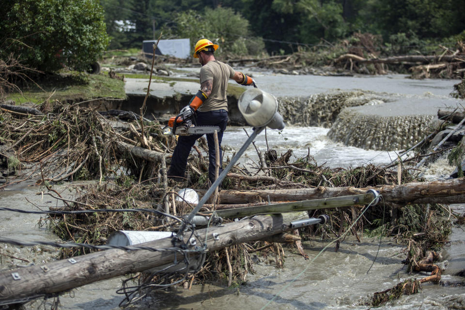 Zac Drown, de la empresa eléctrica de Lyndon, limpia escombros tras los daños causados por las inundaciones en Lyndon, Vermont, el martes 30 de julio de 2024. (AP Photo/Dmitry Belyakov)