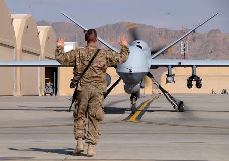 A U.S. airman guides a U.S. Air Force MQ-9 Reaper drone as it taxis to the runway at Kandahar Airfield, Afghanistan March 9, 2016. To match Exclusive AFGHANISTAN-DRONES/ REUTERS/Josh Smith/File photo