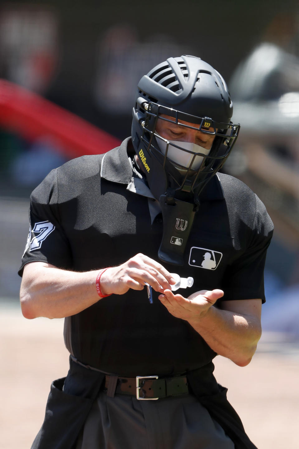 FILE - In this July 16, 2020, file photo, umpire Carlos Torres (37) sanitizes his hands between batters during an Atlanta Braves intrasquad baseball game in Atlanta. Public health experts have mixed feelings about baseball’s hopes to open its season July 23. The field of play — even the batter's box — should be fairly safe, except perhaps for the catcher and plate umpire. (AP Photo/John Bazemore, File)