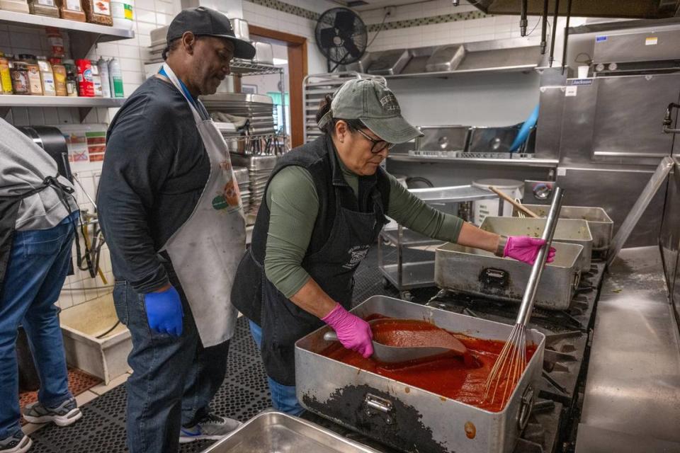 Chef Edwin Burton of Loaves & Fishes, left, looks on as volunteer Ja’net Blea cooks on one of the stoves that is working on Wednesday, Nov. 15. The Sacramento nonprofit dedicated to feeding the hungry and sheltering the homeless is asking for new stoves. Renée C. Byer/rbyer@sacbee.com