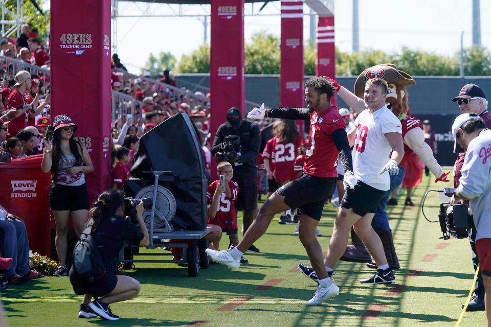 San Francisco 49ers' Spencer Waege (69) and Ronnie Bell, middle, dance in front of fans during the NFL team's football training camp in Santa Clara, Calif., Wednesday, July 26, 2023. (AP Photo/Jeff Chiu)