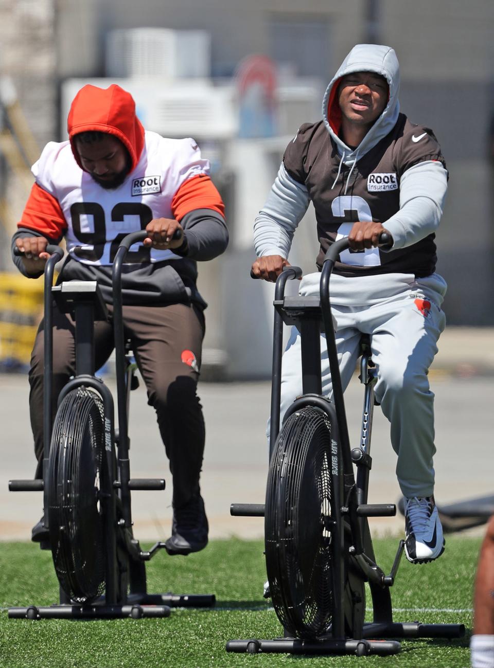 Cleveland Browns wide receiver Amari Cooper, right, rides an exercise bike on the sideline during the NFL football team's football training camp in Berea on Tuesday.