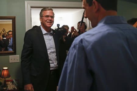 Former Florida Governor Jeb Bush (L) smiles at Fergus Cullen at his house party during a campaign stop in Dover, New Hampshire March 13, 2015. REUTERS/Shannon Stapleton