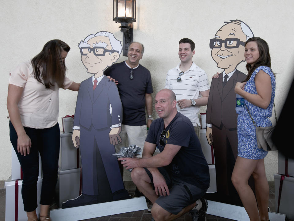 Shareholders pose with cardboard cartoons of Berkshire Hathaway chairman and CEO Warren Buffett, left, and his vice chairman Charlie Munger outside the Berkshire-owned Borsheims jewelry store in Omaha, Neb., Friday, May 4, 2012. Berkshire Hathaway is expected to have 30,000 shareholders come to Omaha for it's annual shareholders meeting this weekend. (AP Photo/Nati Harnik)