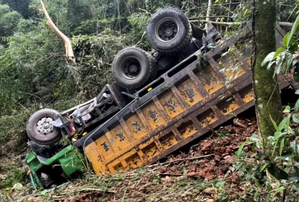 南投縣國姓鄉南港村九份二山山區產業道路發生砂石車摔落約二十公尺深的山谷，陳姓司機卡在嚴重扭曲變形的駕駛座內，經警消救出已明顯死亡。（記者陳金龍翻攝）