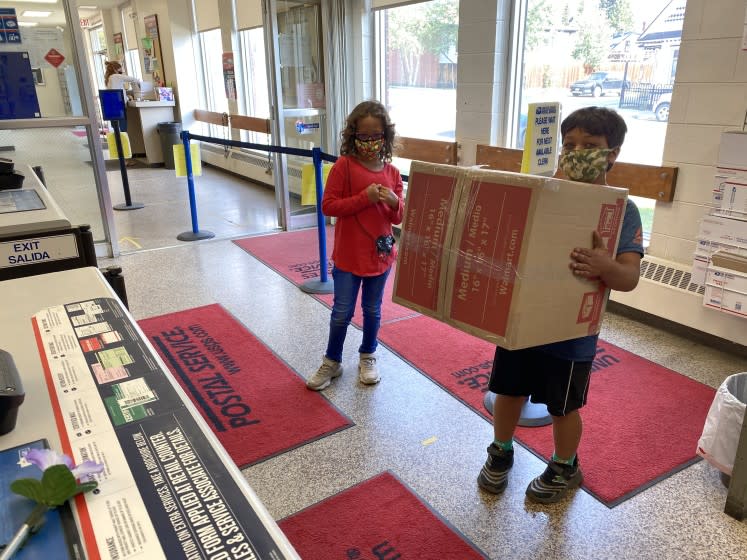 Young customers wait to mail a package Aug. 20 at the Leadville, Colo., post office.