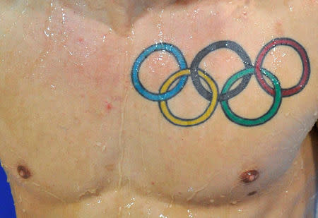 A tattoo of the Olympic rings is seen on Nicholas Robinson Baker of Britain after he dives during the Men's Synchronised 3m Springboard preliminary round at the FINA Diving World Cup at the Olympic Aquatics Centre in London February 20, 2012. REUTERS/Toby Melville/File Photo