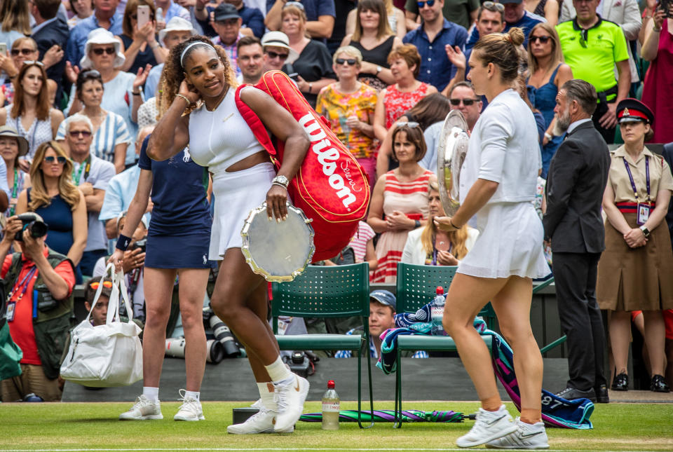 Serena Williams and Simona Halep hold their trophies.