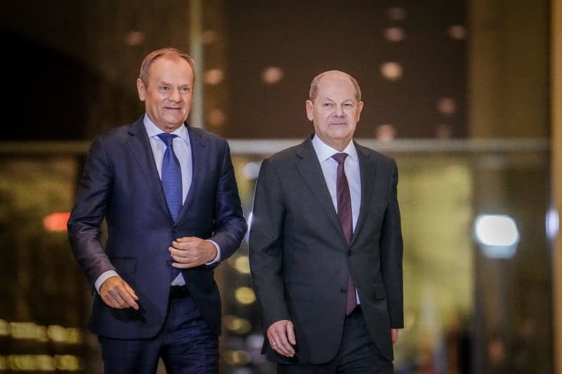 Polish Prime Minister Donald Tusk (L) and German Chancellor Olaf Scholz arrive for a press conference after their meeting at the Federal Chancellery. Kay Nietfeld/dpa