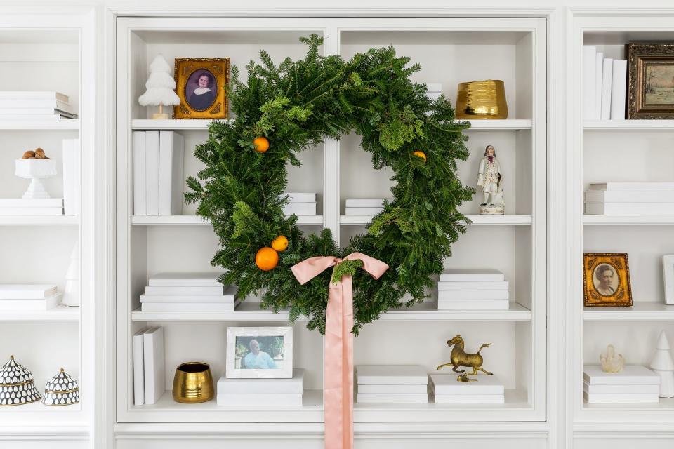 <p>Wreaths aren't just for the holidays. Transform any bookcase into a conversation starter with the addition of an oversized wreath. Simply add a pretty bow and any faux citrus of choice to make it right for the season. </p>