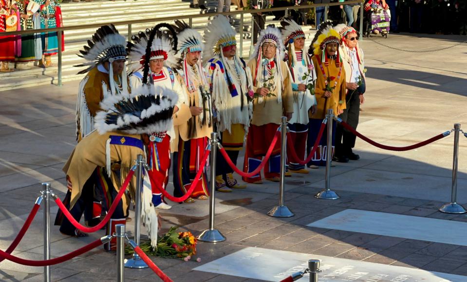 Members of the Chief Plenty Coups Honor Guard lay flowers and salute at the front of the Tomb of the Unknown Soldier Plaza.