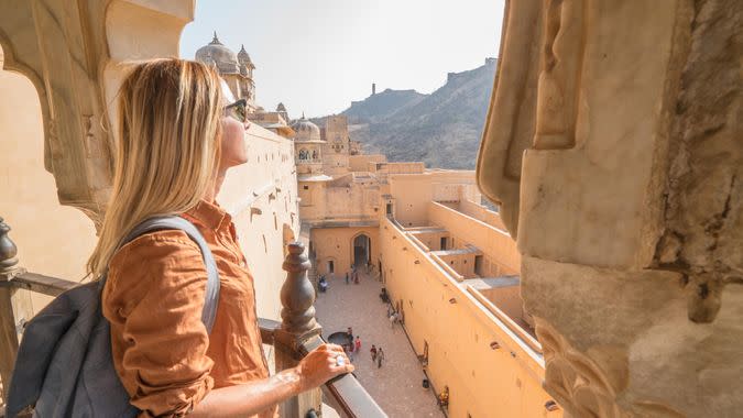 Young woman traveling in India contemplating ancient temple in Jaipur, India.