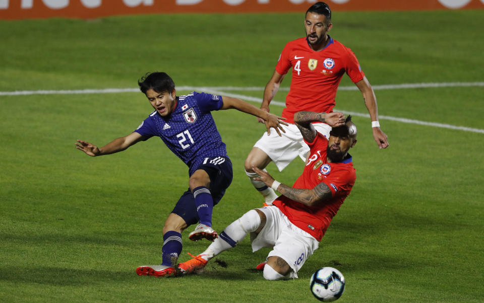 Japan's Takefusa Kubo, left, and Chile's Arturo Vidal, compete for the ball during a Copa America Group C soccer match at the Morumbi stadium in Sao Paulo, Brazil, Monday, June 17, 2019. (AP Photo/Nelson Antoine)