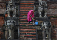 A Nepalese cleaner sweeps the stairs of temple during lockdown in Bhaktapur, Nepal, Tuesday, May 26, 2020. Nepal's lockdown imposed on March 24 to stop the spread of the coronavirus has been extended to June 2. (AP Photo/Niranjan Shrestha)