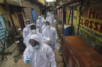 Health workers arrive to administer a free medical checkup in a slum in Mumbai, India, Sunday, June 28, 2020. India is the fourth hardest-hit country by the COVID-19 pandemic in the world after the U.S., Russia and Brazil. (AP Photo/Rafiq Maqbool)