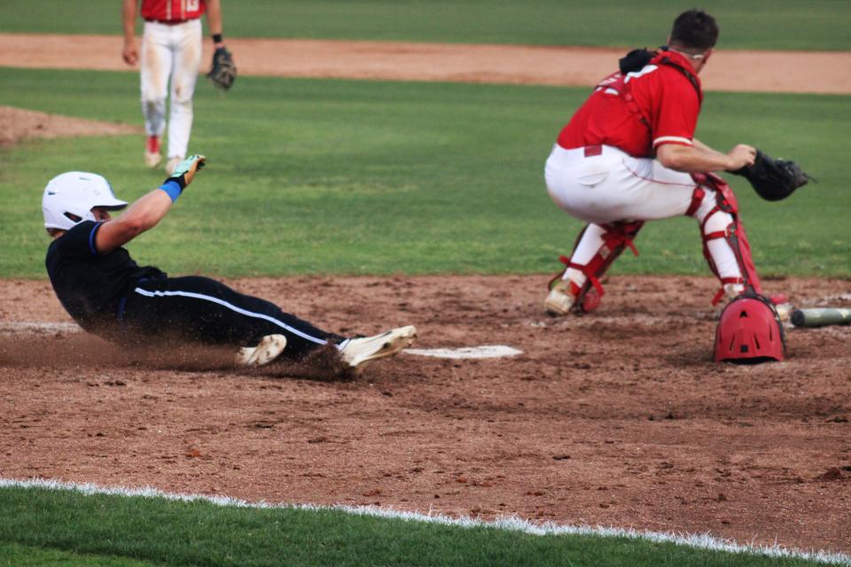 Trinity Christian's Aiden Arnett (17) slides home to score a run against Bishop Snyder in the fifth inning of Tuesday's Region 1-3A baseball final.