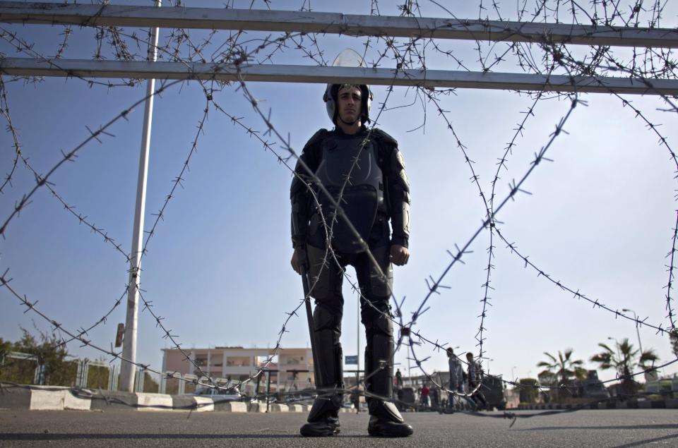 A policeman stands guard outside a courthouse during the trial of Egypt's toppled President Mohammed Morsi in Cairo, Egypt, Tuesday, Jan. 28, 2014. Morsi has arrived in Cairo for the start of his trial Tuesday over charges he and some 130 others face for prison breaks during the country's 2011 revolution, the state news agency reported. (AP Photo/Khalil Hamra)