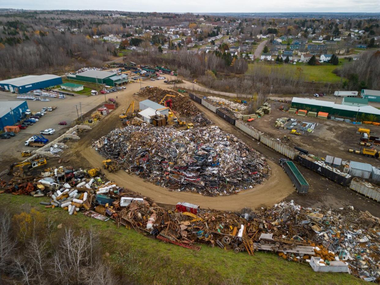 The American Iron and Metal scrapyard in Moncton, pictured here on Nov. 14, as well as the Fredericton and east Saint John sites, must meet National Fire Code limits on size and distance between scrap piles by Feb. 7 under the agreement. (Roger Cosman/CBC - image credit)