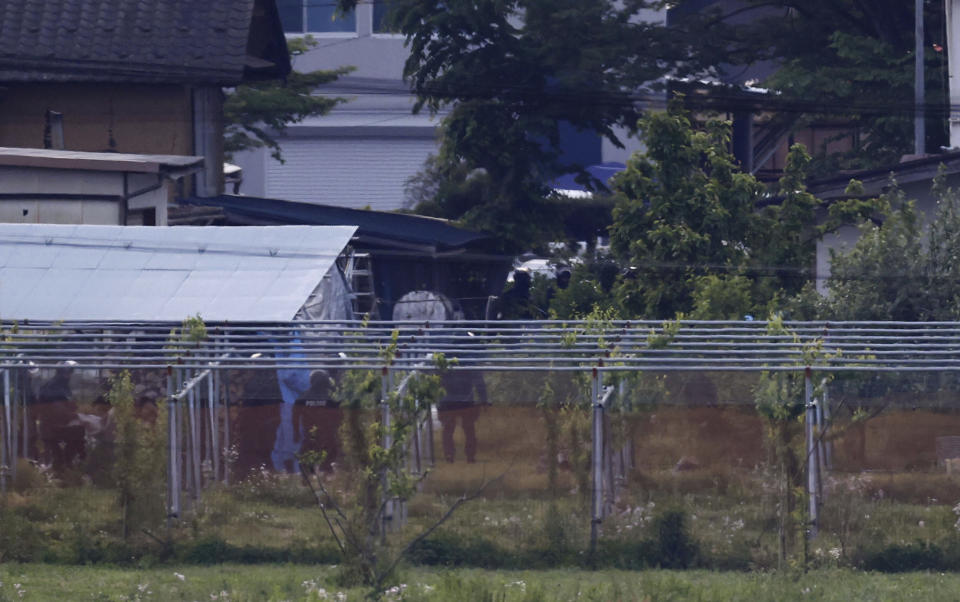 Police officers stand guard around the site of an incident in Nakano, Nagano prefecture, central Japan Friday morning, May 26, 2023. Japanese police captured a suspect with a rifle and knife who had holed up inside a house after killing four people, including two police officers, was arrested early Friday after an hourslong standoff, according to news reports. (Kyodo News via AP)