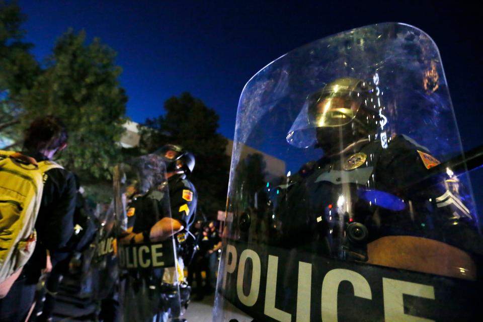 El Paso police in riot gear stand watch as the Brown Berets del Chuco lead a protest in memory of George Floyd and call for justice for victims of police brutality on June 2, 2020, in Downtown El Paso.