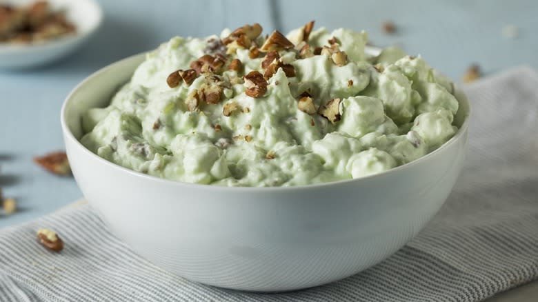 A bowl of Watergate salad topped with walnuts