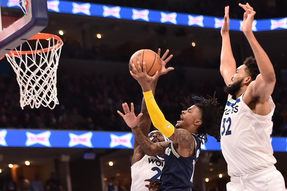 MEMPHIS, TENNESSEE - APRIL 19: Ja Morant #12 of the Memphis Grizzlies goes to the basket against Patrick Beverley #22 and Karl-Anthony Towns #32 of the Minnesota Timberwolves during Game Two of the Western Conference First Round at FedExForum on April 19, 2022 in Memphis, Tennessee. NOTE TO USER: User expressly acknowledges and agrees that , by downloading and or using this photograph, User is consenting to the terms and conditions of the Getty Images License Agreement.  (Photo by Justin Ford/Getty Images)