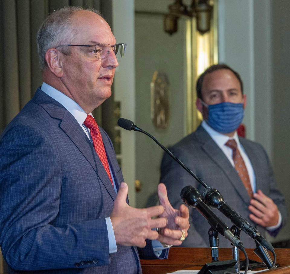 Dr. Joseph Kanter, State Health Officer and Medical Director, right, listens as Gov. John Bel Edwards discusses the public health emergency order and statewide mask mandate while speaking during a media briefing on Louisiana's response to COVID-19 Tuesday Oct. 26, 2021, in Baton Rouge, La. Edwards said Louisiana is ending its statewide indoor mask mandate after emerging from its latest and worst coronavirus spike of the pandemic and seeing a sharp decline in new COVID-19 infections. (Bill Feig/The Advocate via AP)