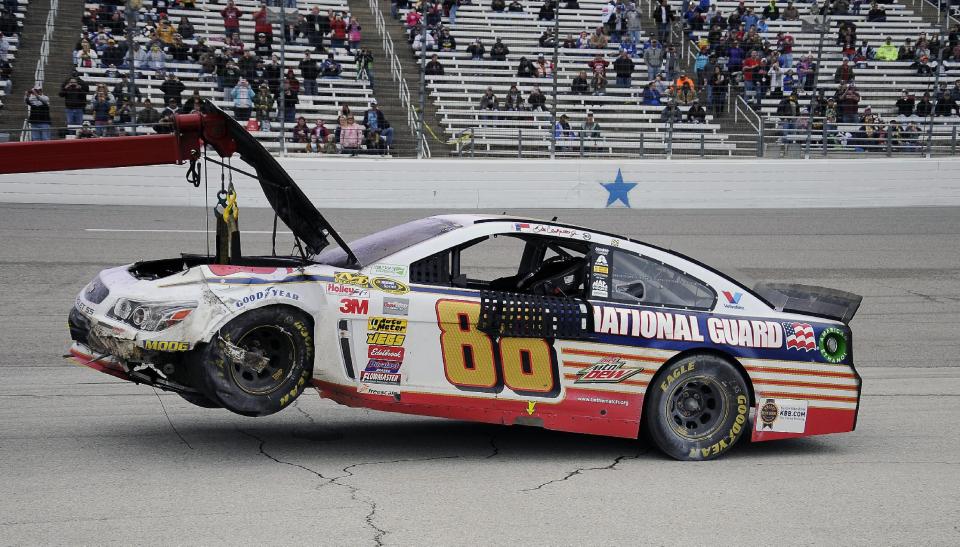 Dale Earnhardt Jr.'s (88) car is towed off the track after a wreck during the NASCAR Sprint Cup series auto race at Texas Motor Speedway, Monday, April 7, 2014, in Fort Worth, Texas. (AP Photo/Larry Papke)