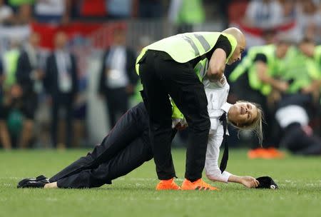 Soccer Football - World Cup - Final - France v Croatia - Luzhniki Stadium, Moscow, Russia - July 15, 2018 A steward apprehends a pitch invader REUTERS/Darren Staples