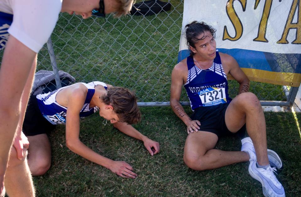 Jonah Archer (right) and Luke Poarch (center, both Northwest Christian School) recover after their team won the Division 4 Boys AIA State Cross Country State Championship, November 13, 2021, at the Cave Creek Golf Course, 15202 N. 19th Ave., Phoenix.