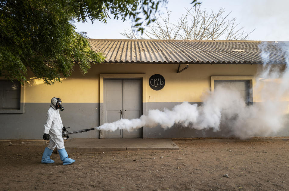 In this Wednesday, April 1, 2020, photo, a municipal worker sprays disinfectant at a school to help curb the spread of the new coronavirus in Dakar, Senegal. The new coronavirus causes mild or moderate symptoms for most people, but for some, especially older adults and people with existing health problems, it can cause more severe illness or death. (AP Photo/Sylvain Cherkaoui)