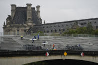 Workers dismantle grandstands on Pont du Carrousel in front of the Louvre Museum, as areas around the Seine River begin to reopen following Friday's opening ceremony at the 2024 Summer Olympics, Saturday, July 27, 2024, in Paris, France. (AP Photo/Rebecca Blackwell)