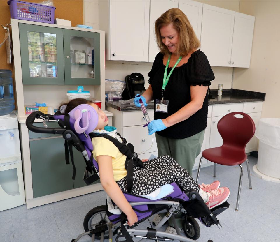 Eileen Vero, a Licensed Practical Nurse prepares to feed Ellie Colon, 7, in the nurses office at the Jesse J. Kaplan School in West Nyack, Oct. 5, 2023.