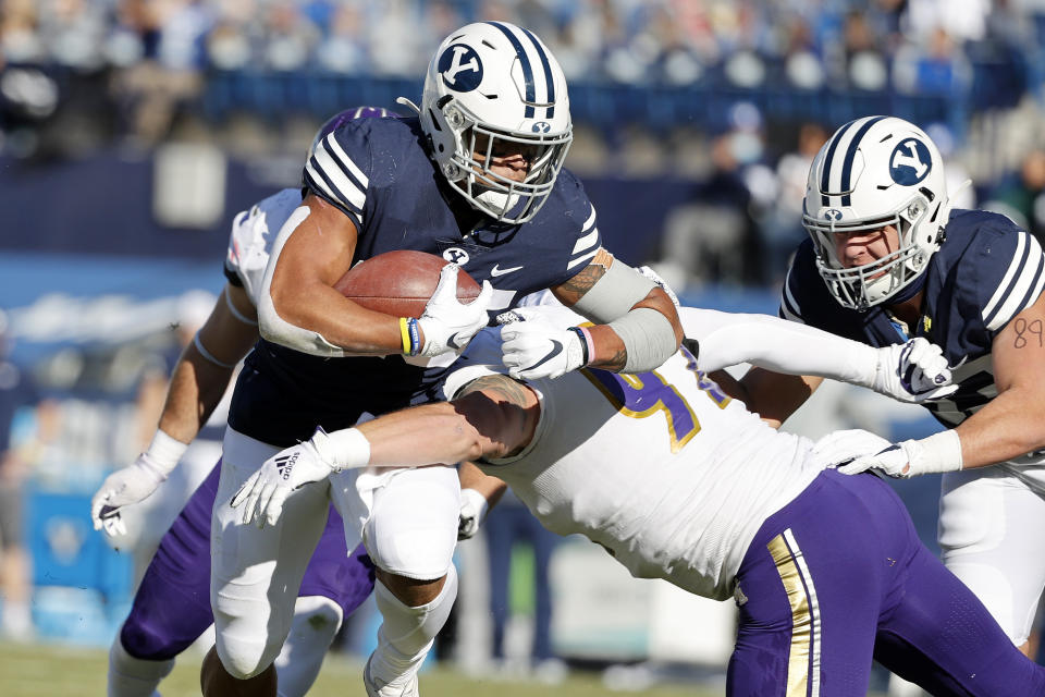 BYU running back Tyler Allgeier (25) runs the ball for a touchdown in the first quarter against North Alabama defensive lineman Charlie Ryan (92) during an NCAA college football game Saturday, Nov. 21, 2020, in Provo, Utah. (AP Photo/Jeff Swinger, Pool)