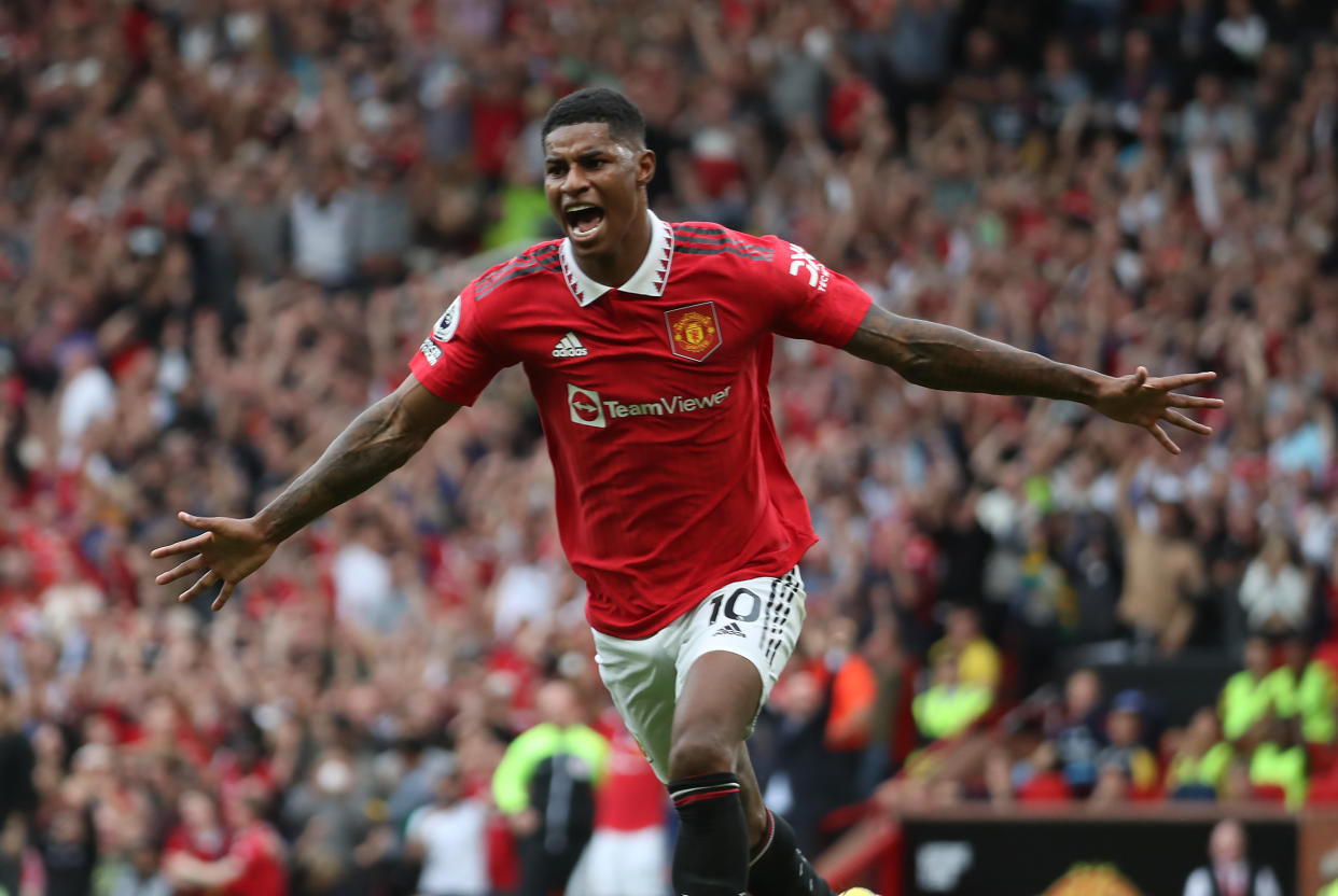Manchester United striker Marcus Rashford runs away arms outstretched in celebration after scoring their second goal against Arsenal.