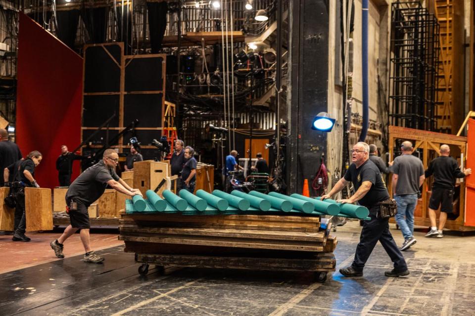 Workers move pieces of a roof during a set change.