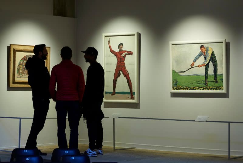 Visitors look at paintings by Holder at the Fondation Gianadda in Martigny