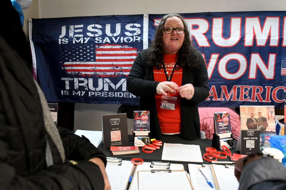 Shawna Sundberg volunteers at a booth for gubernatorial candidate Rev. Niel Petersen at Friday's stop of the ReAwaken America Tour at Trinity Gospel Temple in Canton.