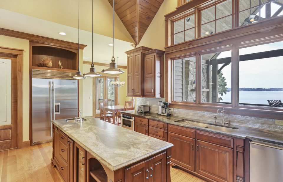 The gourmet kitchen has high-end appliances and vaulted wood ceiling, Butler’s pantry, and lakeside views from kitchen and breakfast room