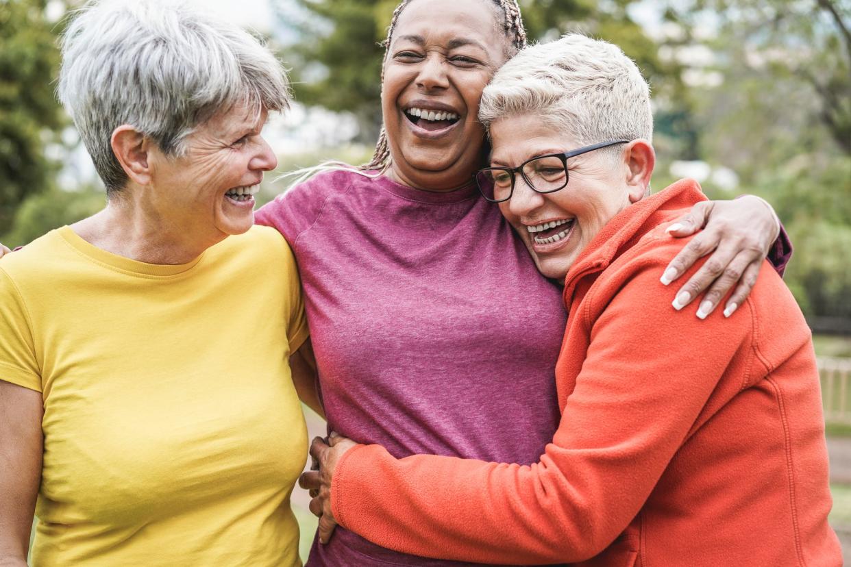 Multiracial senior women having fun together after sport workout outdoor - Main focus on african female face