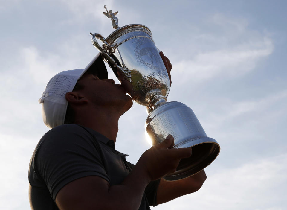 FILE - In this June 17, 2018, file photo, Brooks Koepka holds up the trophy after winning the U.S. Open Golf Championship, in Southampton, N.Y. Koepka has won PGA Tour player of the year on the strength of his two major championships. (AP Photo/Carolyn Kaster, File)