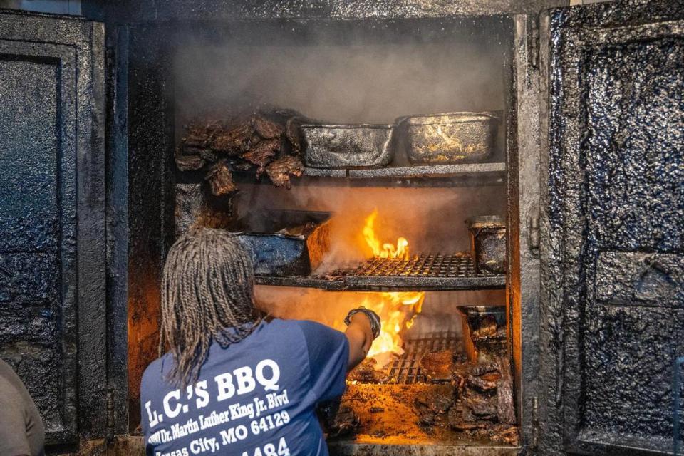 LC’s Bar-B-Q owner Tausha Hammett sprays down the smoking pit. It’s the smoke that contributes to the meat’s texture and flavor.