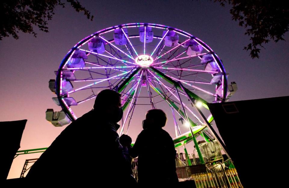 Sacramento City Councilman Steve Hansen, left, shares a moment with his 2-year-old son, Henry Hansen, as they prepare to ride the 65’ Waterfront Wheel during a preview event on Front Street on Wednesday, Oct. 28, 2020, in Old Sacramento. The new fixture is part of a multi-phased marketing campaign by the Downtown Sacramento Partnership titled “We are Downtown. Together.”