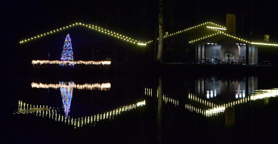 A Christmas tree is reflected in the Waterworks pond on Dec 10, 2021, at Presque Isle State Park in Millcreek Township. The holiday decorations are part of Presque Isle Lights, sponsored by the Presque Isle Partnership. 