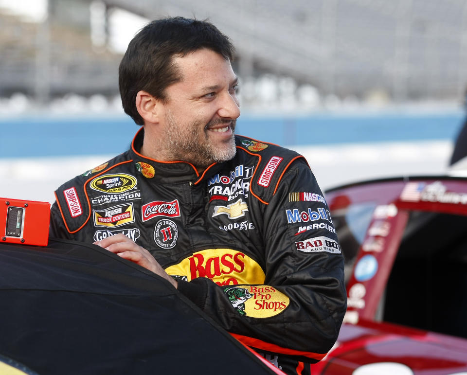 Tony Stewart (14) climbs into his car before qualifying for Sunday's NASCAR Sprint Cup Series auto race on Friday, Feb. 28, 2014, in Avondale, Ariz. (AP Photo/Rick Scuteri)