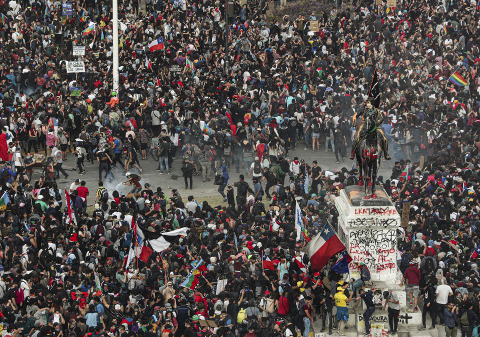 Police and demonstrators clash during an anti-government protest in Santiago, Chile, Monday, Nov. 4, 2019. Thousands of Chileans took to the streets again Monday to demand better social services, some clashing with police, as protesters demanded an end to economic inequality even as the government announced that weeks of demonstrations are hurting the country's economic growth. (AP Photo/Esteban Felix)