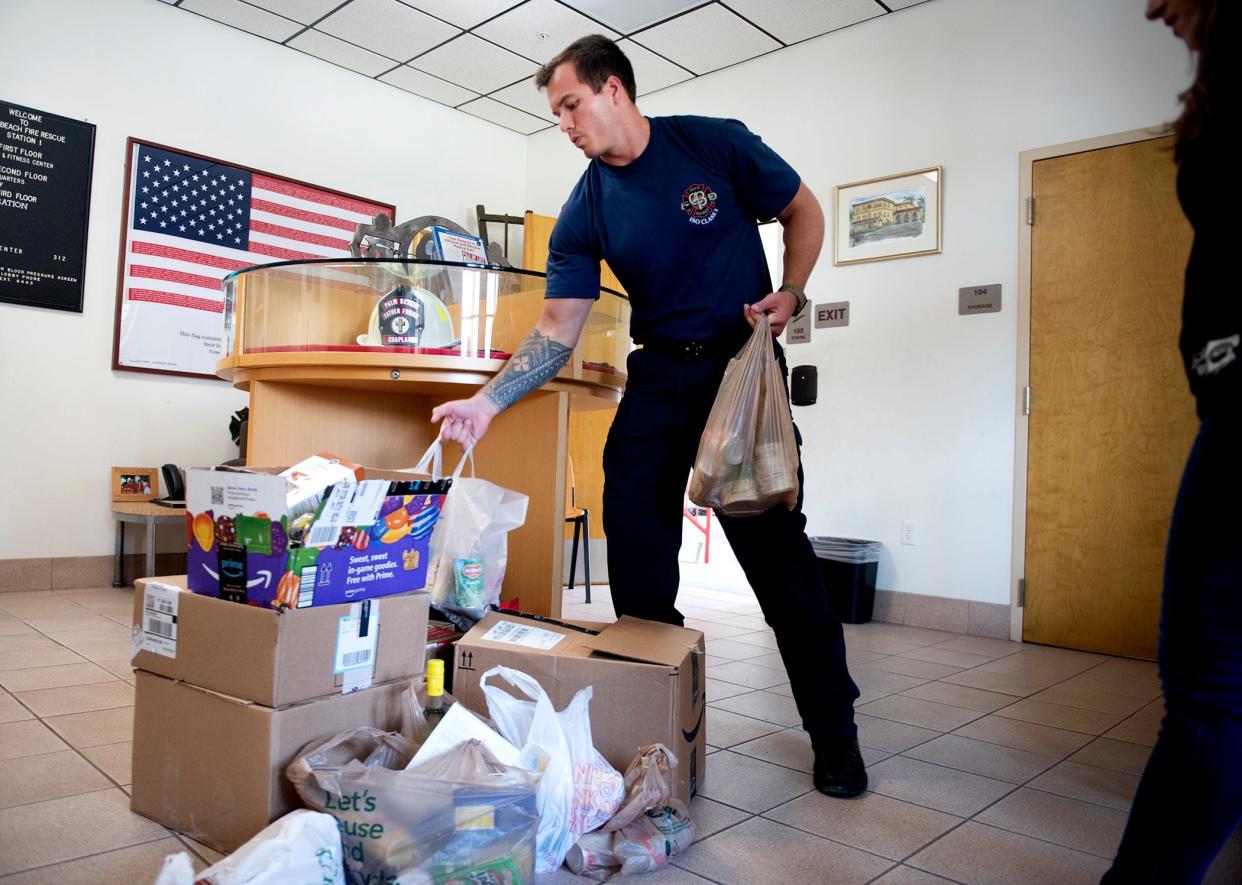 Palm Beach firefighter paramedic Austin Bradshaw helps load food for the Homeless Coalition of Palm Beach County in April 2023 as part of the Town of Palm Beach United Way's 10th annual Empty Your Pantry Food Drive.