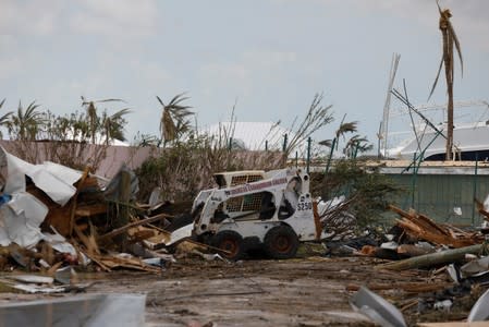 A man in a bobcat lifter cleans debris from a street after Hurricane Dorian hit the Abaco Islands in Treasure Cay